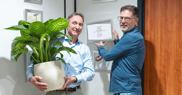 Xylander en Frank hangen het nieuwe certificaat aan muur.