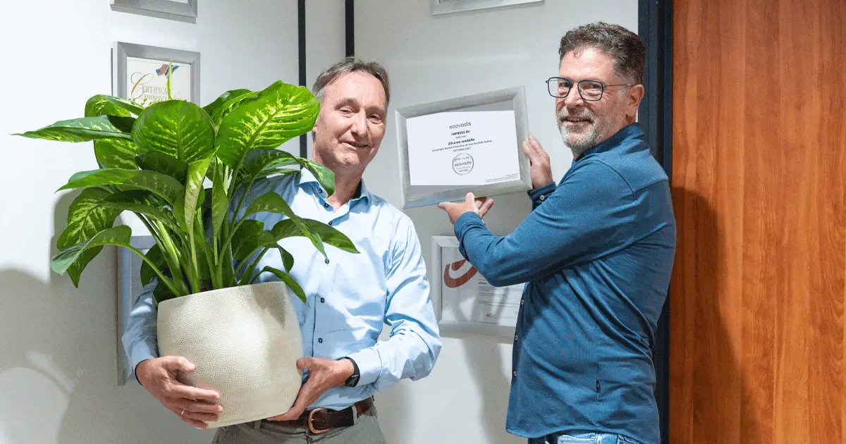 Xylander en Frank hangen het nieuwe certificaat aan muur.